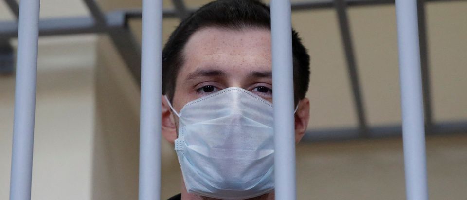 FILE PHOTO: Former U.S. Marine Trevor Reed, who was detained in 2019 and accused of assaulting police officers, stands inside a defendants' cage during a court hearing in Moscow, Russia July 30, 2020. REUTERS/Maxim Shemetov/File Photo