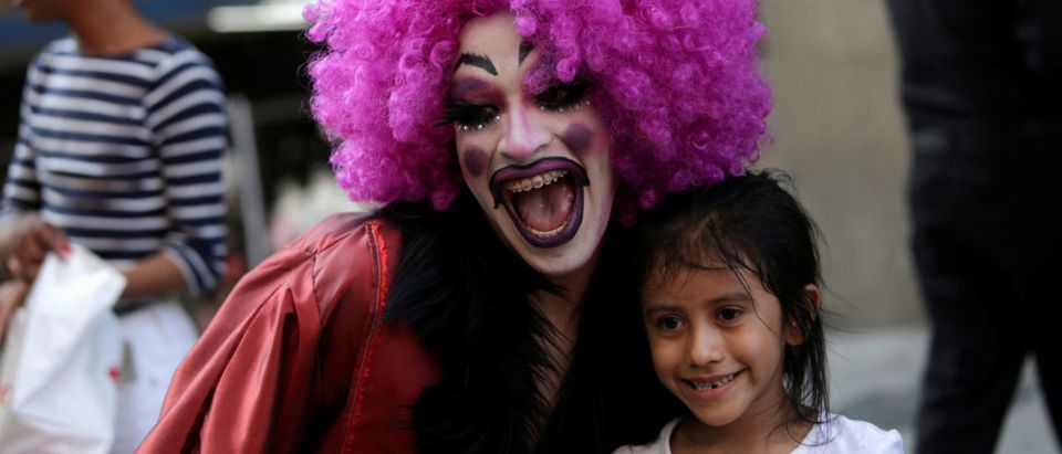 A participant dressed in drag poses for a picture with a child during the "Drag Queen Story Hour" event, which according to organizers involves participants reading stories to children for an hour, in downtown Monterrey