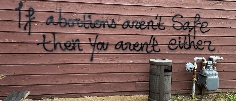 A threat is spray painted on the building wall near Wisconsin Family Action's offices in Madison