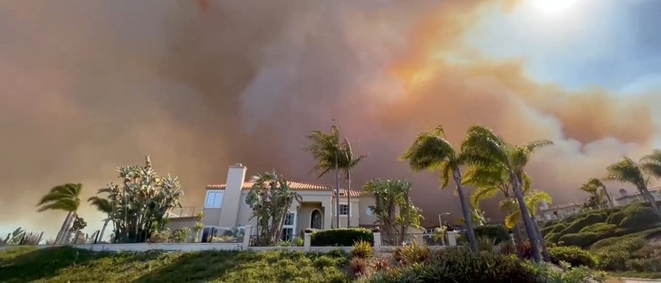 Smoke from a wildfire rises above a residential area in Laguna Niguel