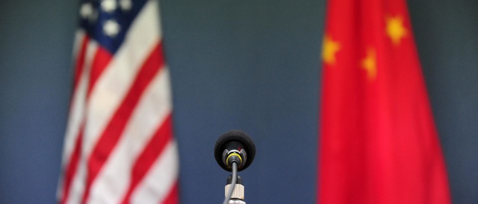The US and China flags stand behind a mi