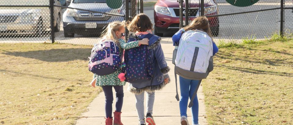 School children wearing facemasks walk outside Condit Elementary School in Bellaire, outside Houston, Texas, on December 16, 2020. (Photo by FRANCOIS PICARD/AFP via Getty Images)