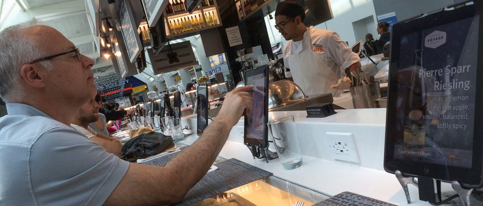 A passenger uses an iPad to order food in a Delta terminal in LaGuardia Airport in New York