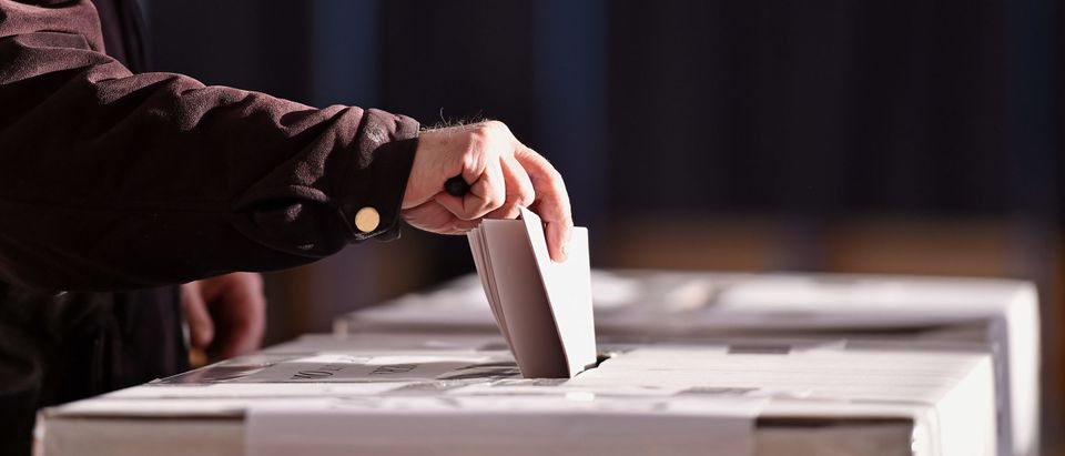 Hand of a person casting a ballot [Shutterstock/roibu]
