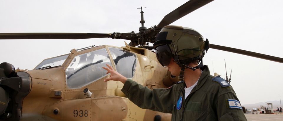 Israeli pilot speaks with media in front of helicopter in southern Israel