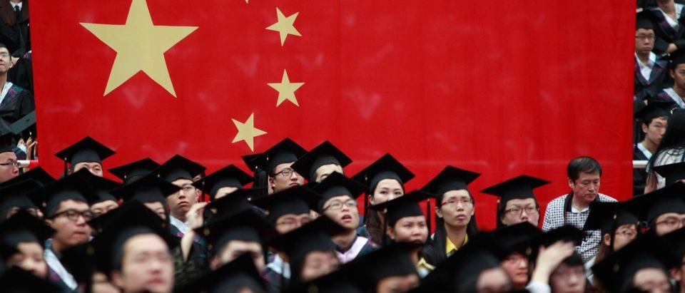 Graduates set next to the Chinese flag during a graduation ceremony at Fudan University in Shanghai June 28, 2013. A record high of 6.99 million students are expected to graduate from college this year which places severe pressure on their search for jobs, according to Xinhua News Agency. (REUTERS/Aly Song)