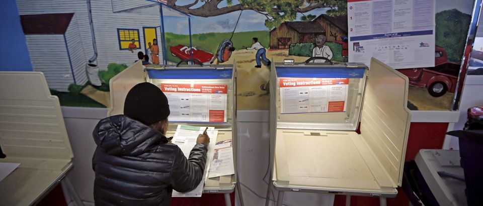A voter casts her ballot during voting in Illinois' U.S. presidential primary election at Jimmie G's restaurant in Chicago