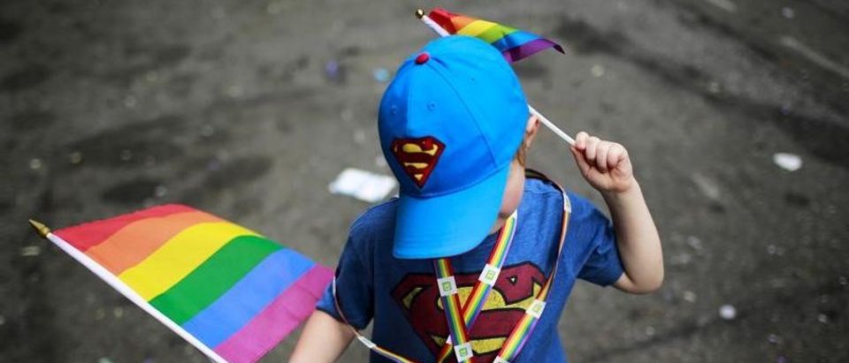 A child carries rainbow flags while he takes part in a march during the annual Gay Pride Parade in New York