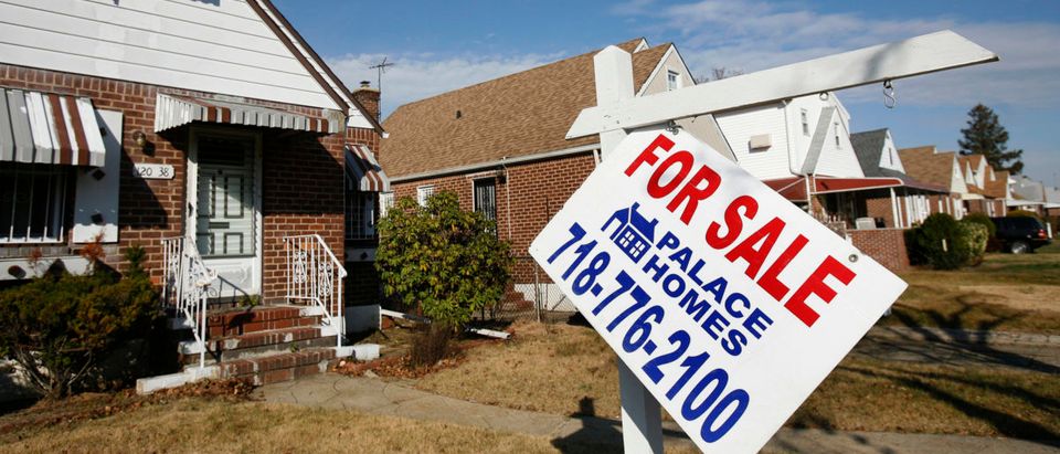A broken "For Sale" sign is seen outside a home in the Queens borough of New York