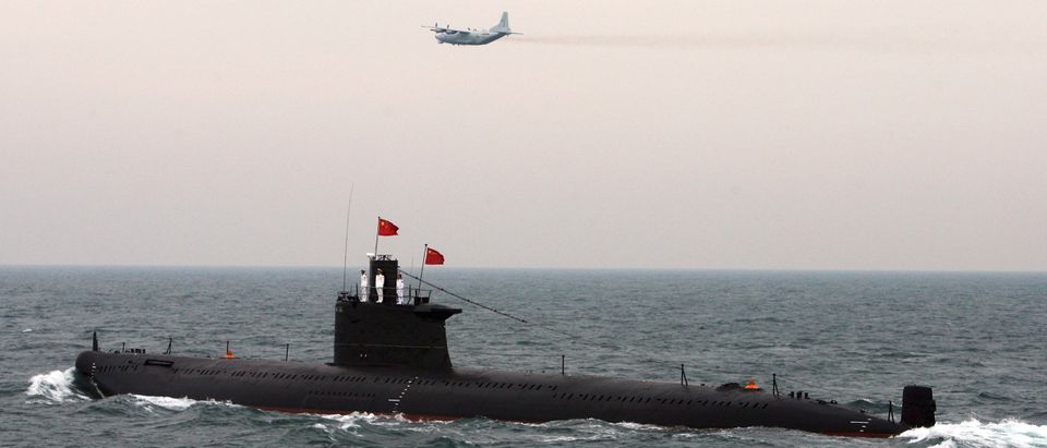 A military aircraft flies past a Chinese Navy submarine at an international fleet review to celebrate the 60th anniversary of the founding of the People's Liberation Army Navy in Qingdao, Shandong province April 23, 2009. (REUTERS/Guang Niu/Pool)