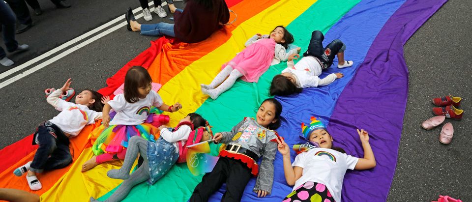 Children play on a giant rainbow flag as they take part in LGBT pride parade in Taipei