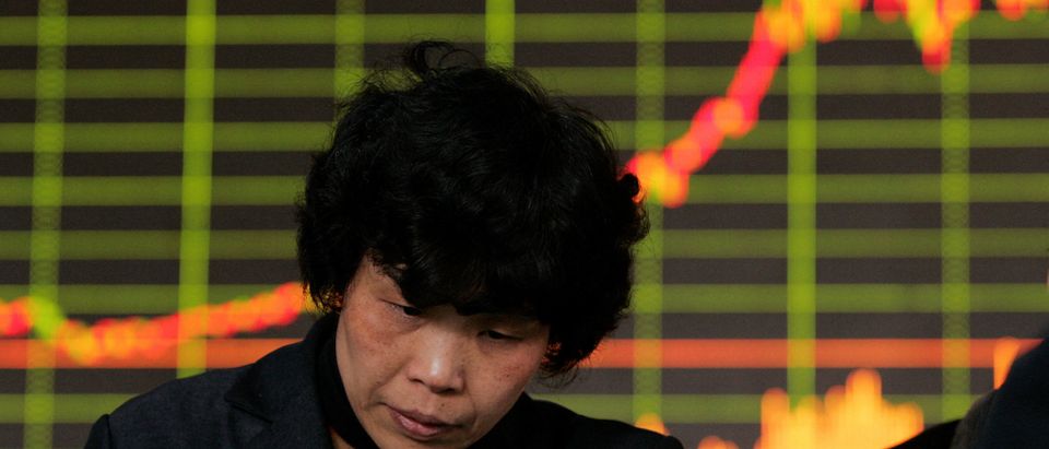 FILE PHOTO: An investor checks stock movements at a stock exchange market in Shanghai