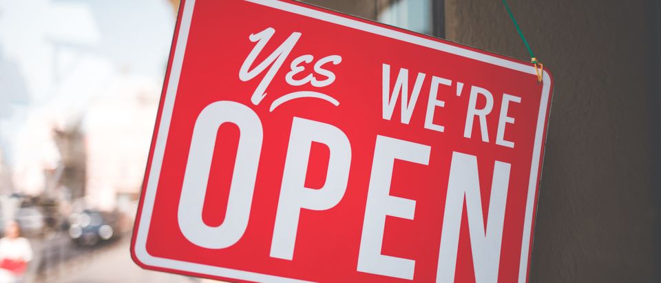 A sign reads "yes, we're open" [Shutterstock Andriiii]