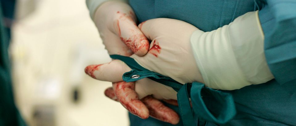 A surgeon folds his hands during an emergency surgery on a seriously injured man at the Unfallkrankenhaus Berlin hospital