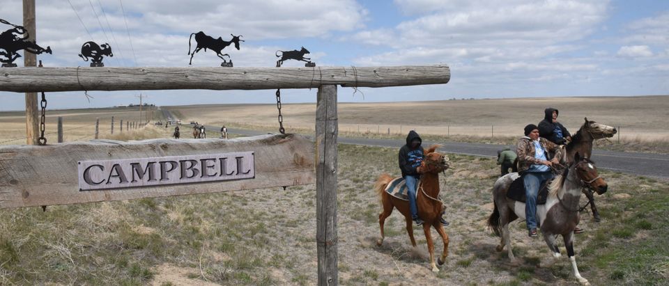 The Fort Laramie treaty riders pass by a sign post displaying the name of a ranch in Torrington, Wyoming