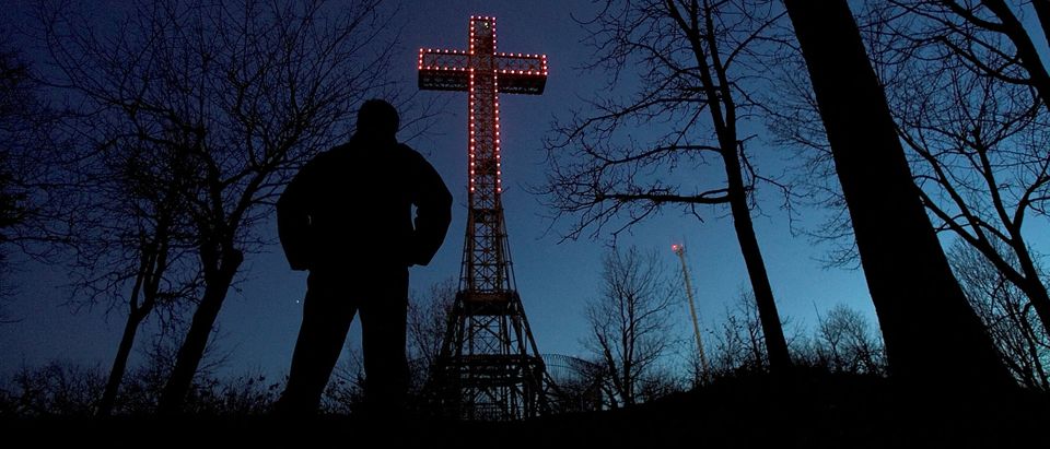 FILE PHOTO: A Montrealer gazes up at purple cross on Mount Royal.
