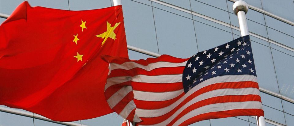 A US and a Chinese flag wave outside a c