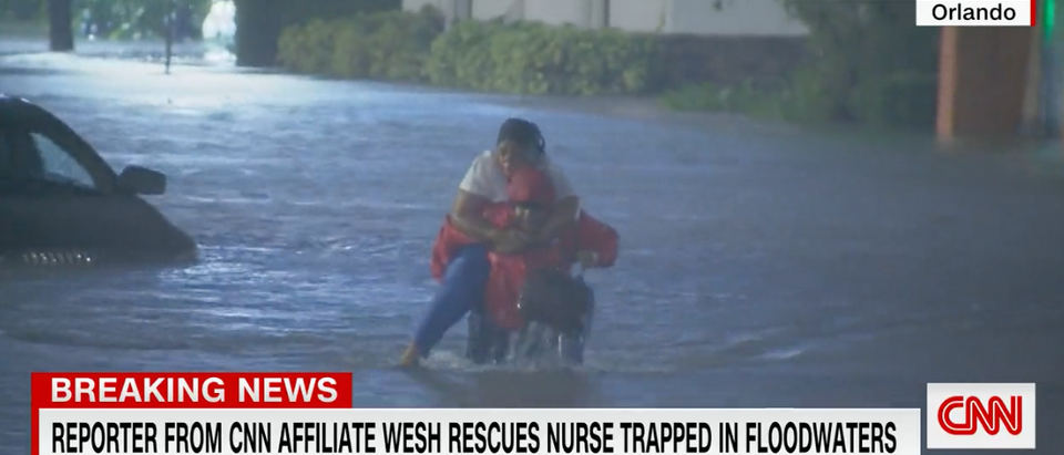 A local Florida reporter is being hailed a hero after he rescued a woman from rising flood waters in Orlando as she tried to drive through them. [Screenshot CNN]