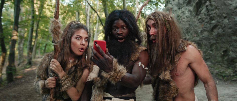 Cheerful,Group,Of,Neanderthal,Hunters,Using,Modern,Technology,Smartphone,Cheering