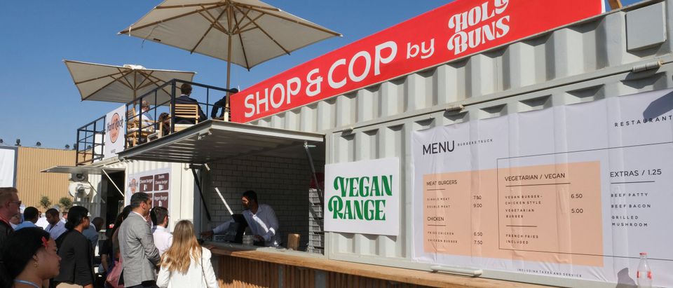 People queue at food stands with vegan options at the COP27 climate summit, in Sharm el-Sheikh