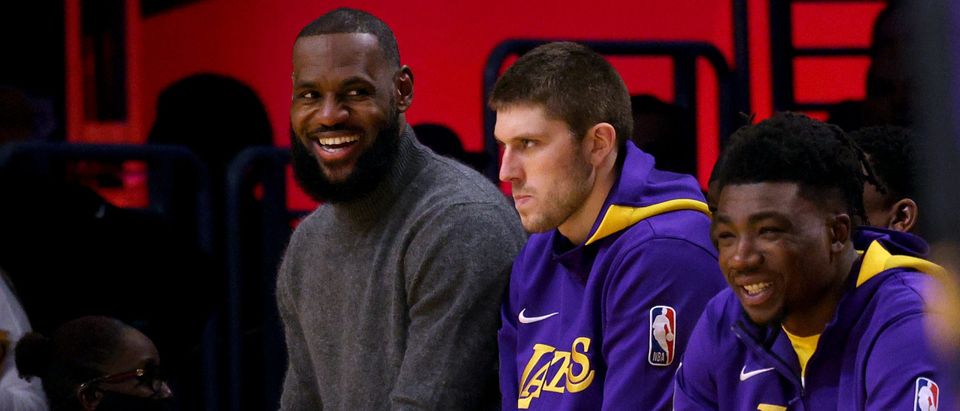 LeBron James #6 of the Los Angeles Lakers smiles on the bench with Matt Ryan #37 and Thomas Bryant #31 during a 128-121 Lakers win at Crypto.com Arena on November 18, 2022 in Los Angeles, California. (Photo by Harry How/Getty Images)