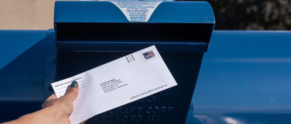 Voter places ballot in mail [Shutterstock Kristen Prahl]
